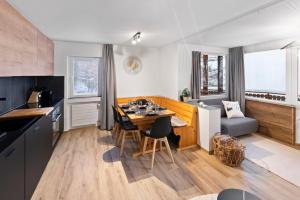 a kitchen and living room with a table and a couch at Appartement rénové avec sauna privé in Saas-Fee