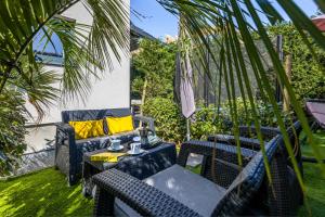 a patio with a table and chairs and palm trees at Villa Valis in Baška