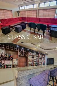 a restaurant with a classico bar with red couches at Roban Hotels Limited in Enugu