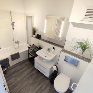 een badkamer met een witte wastafel en een toilet bij Ferienwohnung Moritzwiese in Naumburg