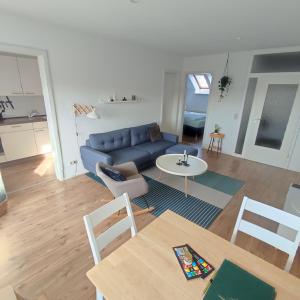 een woonkamer met een blauwe bank en een tafel bij Ferienwohnung Moritzwiese in Naumburg