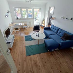 - un salon avec un canapé bleu et une table dans l'établissement Ferienwohnung Moritzwiese, à Naumbourg