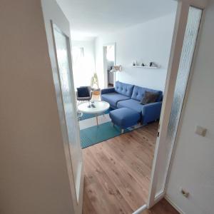een woonkamer met een blauwe bank en een tafel bij Ferienwohnung Moritzwiese in Naumburg