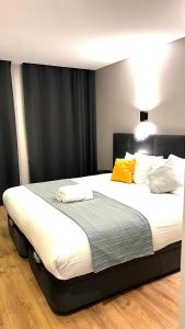 een slaapkamer met een groot bed met 2 gele kussens bij Apartamento Sociedade Farmaceutica in Lissabon
