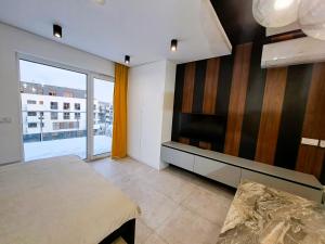 un soggiorno con letto e TV di Kima Apartament Bażantów 40 a Katowice