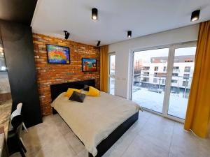 een slaapkamer met een bed en een bakstenen muur bij Kima Apartament Bażantów 40 in Katowice
