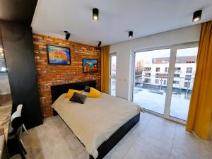 a bedroom with a bed and a brick wall at Kima Apartament Bażantów 40 in Katowice