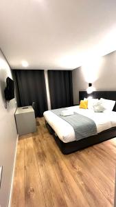 een slaapkamer met een groot bed en een televisie bij Apartamento Sociedade Farmaceutica in Lissabon