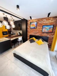 a bedroom with a large bed and a brick wall at Kima Apartament Bażantów 40 in Katowice