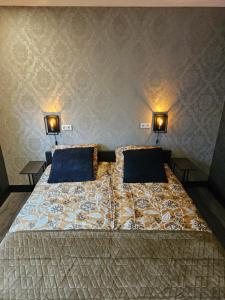 a bedroom with a bed with two lamps on the wall at City Stay Juliette in Enschede