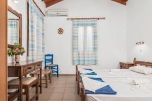 a room with two beds and a table and chairs at Vigla-Βίγλα 1 2 in Órmos Marathokámpou