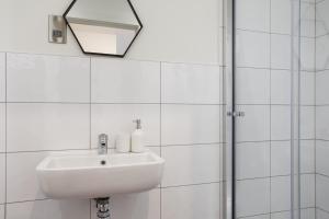 a white bathroom with a sink and a shower at Kemara Apartments - Stunning 2 Bedroom Duplex Apartment in Bradford