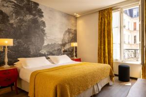 1 dormitorio con 1 cama y una pintura en la pared en Hotel L’Antoine, en París