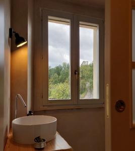 un bagno con una grande vasca bianca di fronte a una finestra di lassù minihotel 