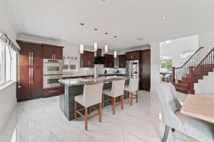 a kitchen with wooden cabinets and a island with bar chairs at Miami Puzzle Lake Escape, Games, Pool, BBQ, Views L58 in Miami