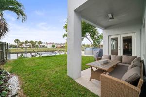 eine Terrasse mit einem Sofa und einem Tisch in der Unterkunft Miami Puzzle Lake Escape, Games, Pool, BBQ, Views L58 in Miami