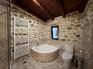 a stone bathroom with a tub and a toilet at Pyrgou Villa Spacious and Unique 1 in Pirgoú