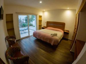 a bedroom with a bed and a sliding glass door at La Cañada in Guanajuato