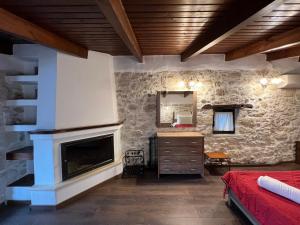 a bedroom with a stone wall with a fireplace at Pyrgou Villa Spacious and Unique 1 in Pirgoú