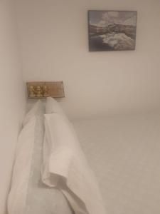 a white room with a bed with white pillows at Space Zen in Valença