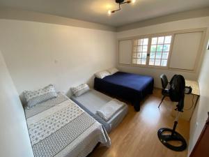 a small bedroom with two beds and a window at neighbor.HUB hostel & coliving FLORIPA in Florianópolis