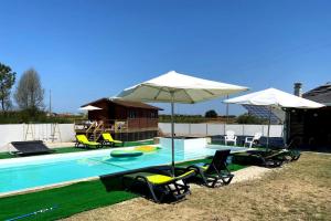 einen Pool mit Stühlen und Sonnenschirmen sowie einem Tisch und Stühlen in der Unterkunft Akicity Vagos Simple in Ponte de Vagos