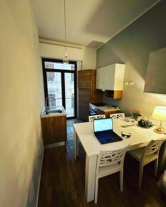 una cocina con mesa y ordenador portátil. en B&B Degli Artisti en Lecce