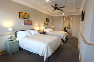 a hotel room with two beds and a ceiling fan at The NuWray Hotel & Carriage House in Burnsville