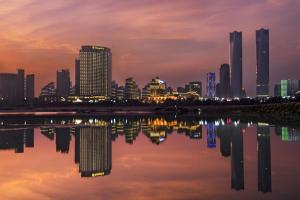 un perfil urbano por la noche con un cuerpo de agua en Shangri-La Nanchang丨All room offer river views Just one stop from the Pavilion of Prince Teng, en Nanchang
