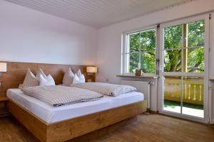 - une chambre avec un grand lit et une fenêtre dans l'établissement Ferienhof Walter, à Fribourg-en-Brisgau