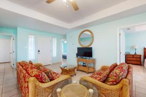 a living room with two couches and a television at Augusta Casita at SPI Golf Course in Laguna Vista