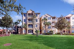 a large apartment building with a green lawn at Family Fiesta in Orlando