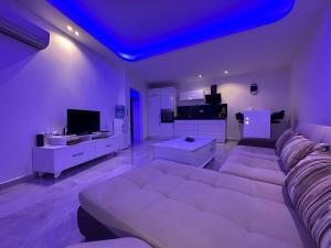 een woonkamer met een witte bank en een blauw plafond bij Lumos SPA ALL-IN apartment in Luxury resort full facilities in Alanya