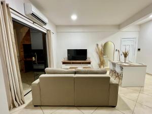 a living room with a couch and a television at Apartamento cerca del Aeropuerto in Colonia Mariano Roque Alonso
