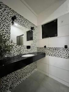 y baño con lavabo y espejo. en Apartamento cerca del Aeropuerto en Colonia Mariano Roque Alonso