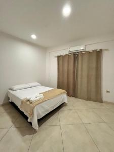 um quarto com uma cama num quarto em Apartamento cerca del Aeropuerto em Colonia Mariano Roque Alonso