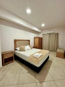 a bedroom with a bed and a nightstand and a bed sidx sidx sidx sidx at Apartamento cerca del Aeropuerto in Colonia Mariano Roque Alonso