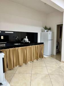 a kitchen with a counter with a sink and a refrigerator at Apartamento cerca del Aeropuerto in Colonia Mariano Roque Alonso