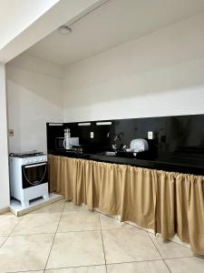 a kitchen with a counter with a sink and a stove at Apartamento cerca del Aeropuerto in Colonia Mariano Roque Alonso