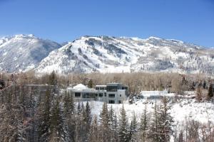 un edificio nella neve con montagne sullo sfondo di Aspen Meadows Resort ad Aspen