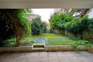 een tuin met een vijver in het midden bij YELLOW House - Terrasse - Proche Paris et transports - Tout équipé in Montfermeil