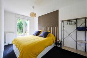 een slaapkamer met een geel bed en een raam bij YELLOW House - Terrasse - Proche Paris et transports - Tout équipé in Montfermeil