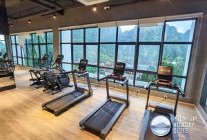 een fitnessruimte met een rij loopbanden en ramen bij Premium Holiday Suite beside Lost World Tambun in Tambun
