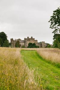 a field of grass with a castle in the background at The West End - Hawarden Castle in Hawarden