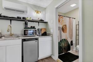 a kitchen with white cabinets and a microwave at Beachside Boutique Suite 4 in Sneads Ferry