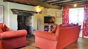 a living room with two chairs and a television at Finest Retreats - Woodend - The Cottage in Ulpha