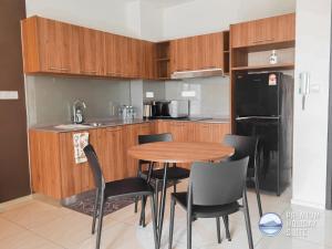 eine Küche mit einem Holztisch und schwarzen Stühlen in der Unterkunft Premium Holiday Suite beside Lost World Tambun in Tambun