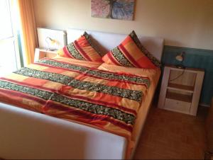 a bed with a colorful blanket on top of it at Ferienhaus Gut Düneburg in Haren