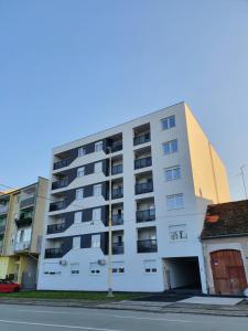 een wit appartementencomplex aan de straatkant bij Apartman Domagoj in Osijek