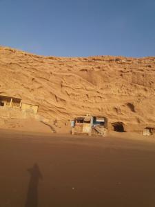 Ein Schatten einer Person, die in der Wüste steht in der Unterkunft Raha Cave Said in Douaïra